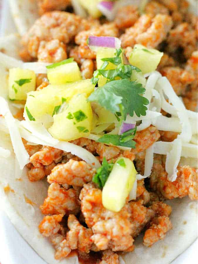 close up photo of the seasoned ground pork taco meat in the taco