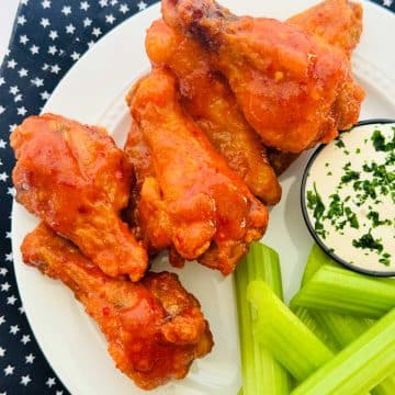 crispy baked buffalo chicken wings plated with celery and blue cheese dressing