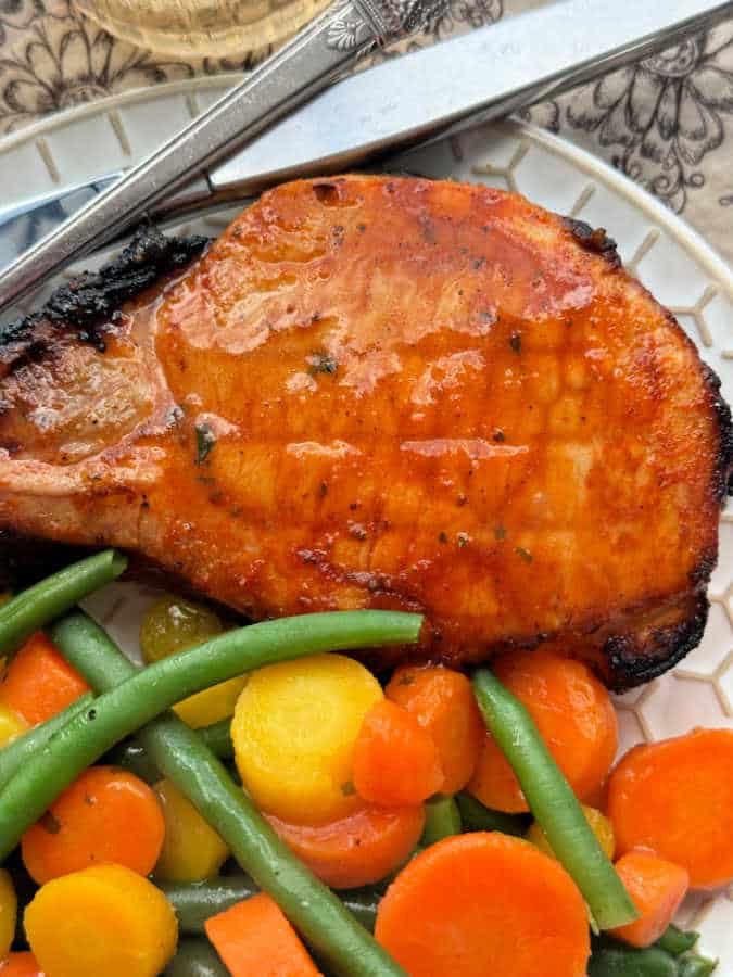 close up photo of broiled pork chop on a plate