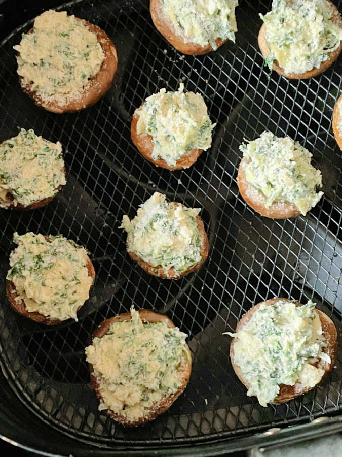 stuffed mushrooms in the basket of the air fryer before cooking