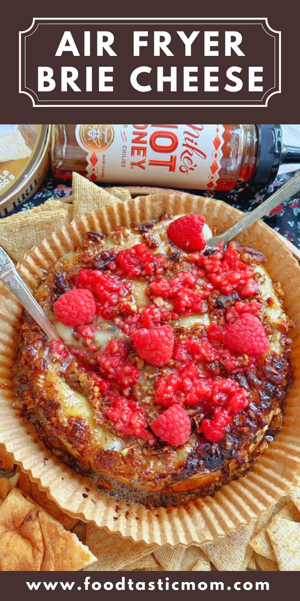 This air fryer baked brie is so quick to make and uses just four ingredients - including brie cheese, pecans, hot honey and fresh raspberries. via @foodtasticmom