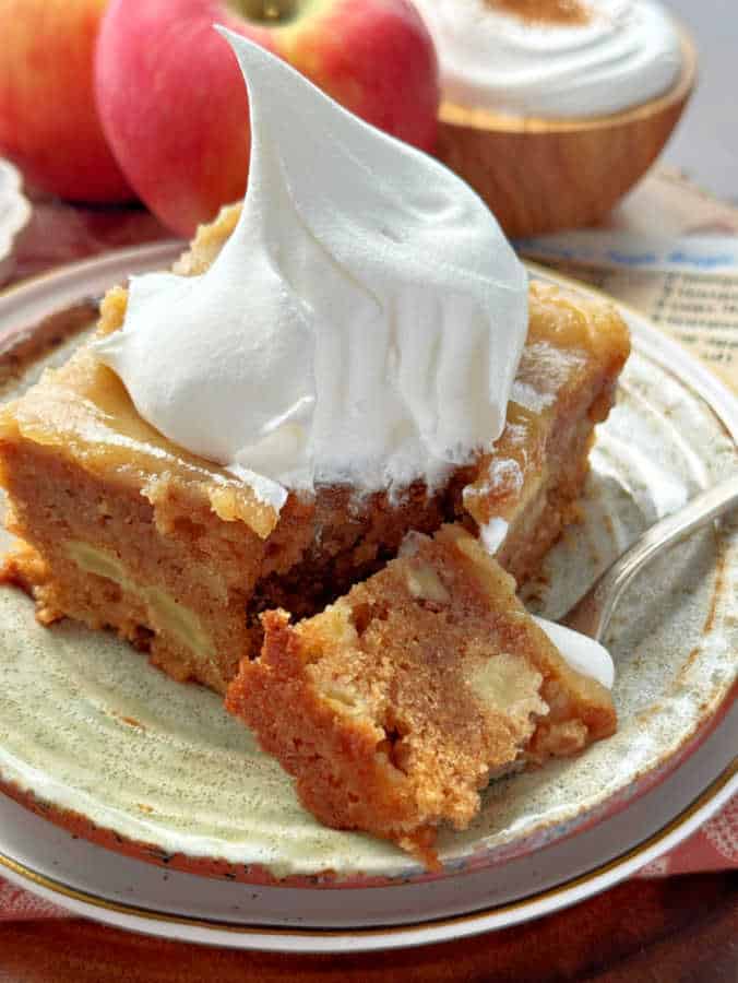 a slice of apple dapple cake topped with a dollop of Cool-Whip