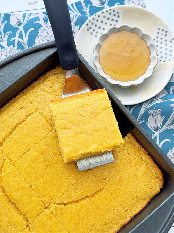 a pan of freshly baked cornbread straight from the oven, sliced and ready to serve