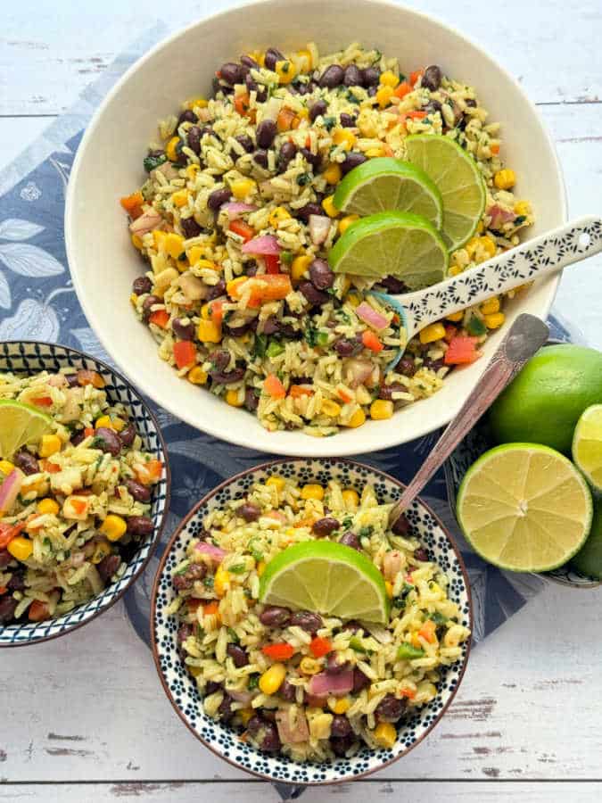 bean and rice salad garnished with lime wedges and ready to serve in small bowls