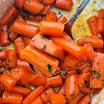 serving a spoonful of glazed carrots garnished with fresh parsley, from the baking dish