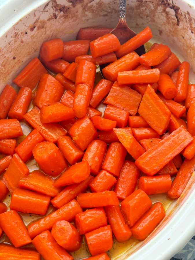 glazed carrots in their baking dish before getting sprinkled with parsley