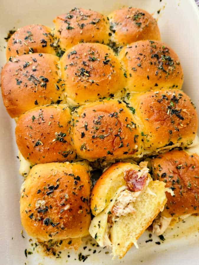 a dish of a dozen baked sliders, ready to serve