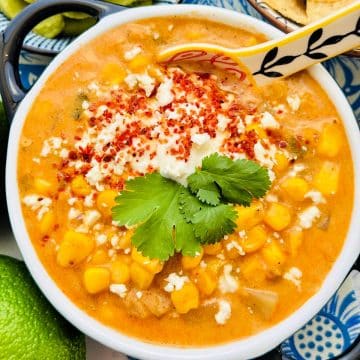 a ceramic crock full of Mexican street corn chowder garnished with Tajin, cilantro and cotija cheese