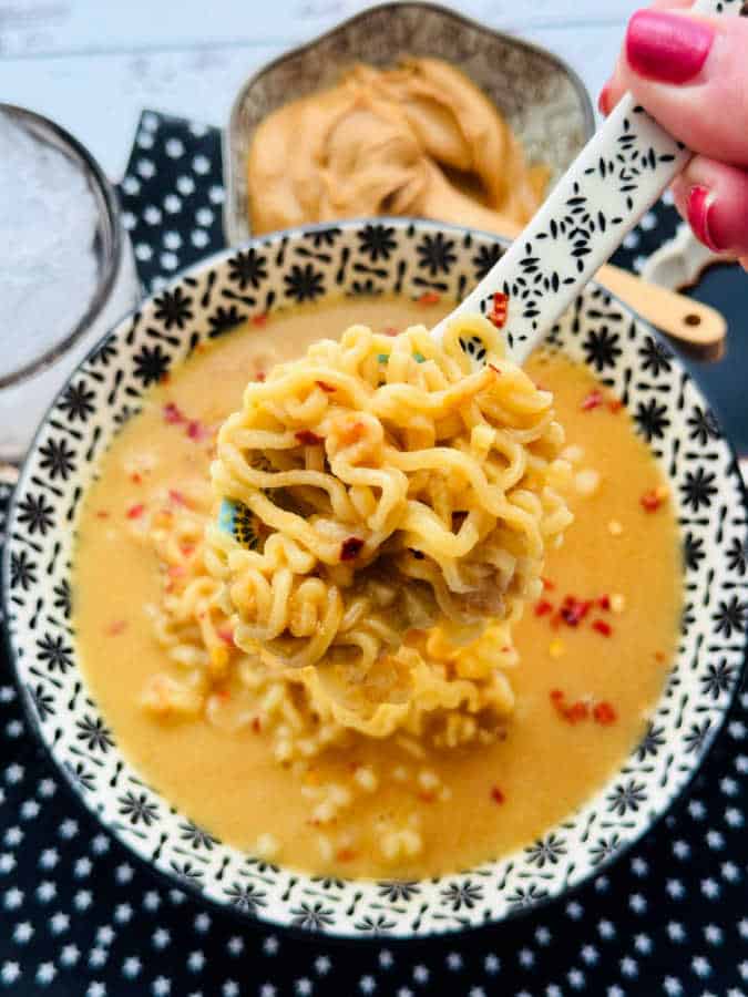 showing a close up of a big spoonful of the prepared ramen noodles with peanut butter