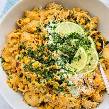 a white serving bowl of Mexican street corn pasta salad